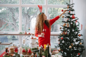 woman decorating a Christmas tree