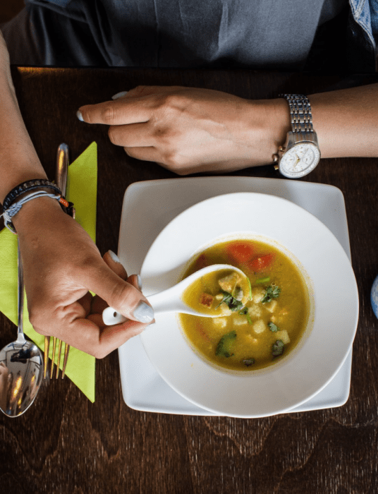 a person eating soup in a bowl