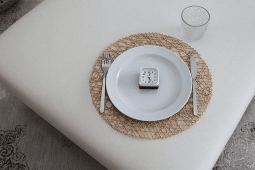 an alarm clock placed in an empty plate