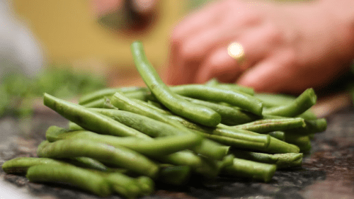 A person chopping green beans